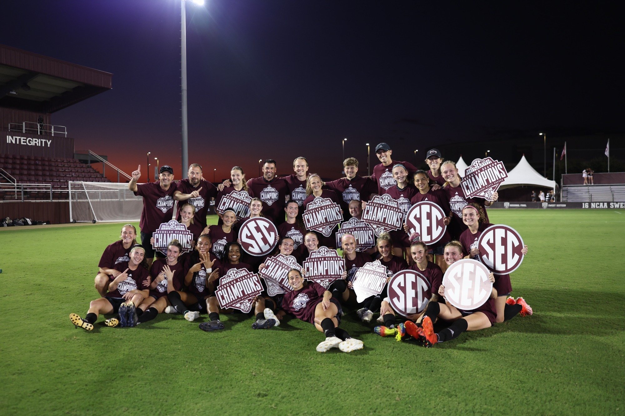 Mississippi State soccer poses with SEC championship signs after clinching the 2024 regular-season title